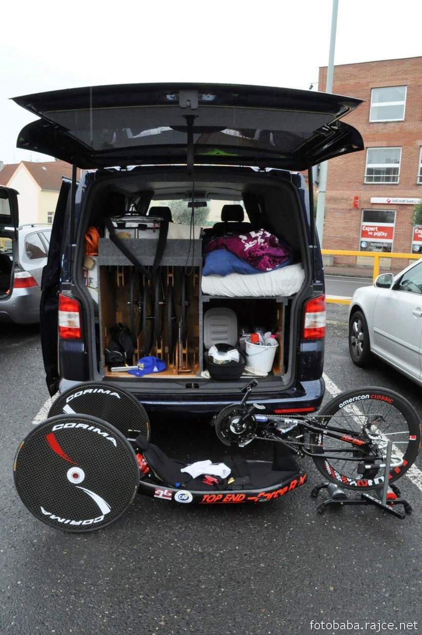 VW Van Transporter back view showing fitted bike wheel rack, bed and storage with Hand cycle on ground